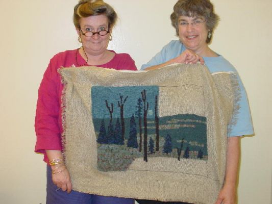 Teacher Jayne Hester - Hunterdon County Rug Artisan Guild Camp 2006
First wide cut by Barbie.  The finished rug is on a foot stool.  The design is from a picture taken from our deck of the moon setting on the Connecticut River.
